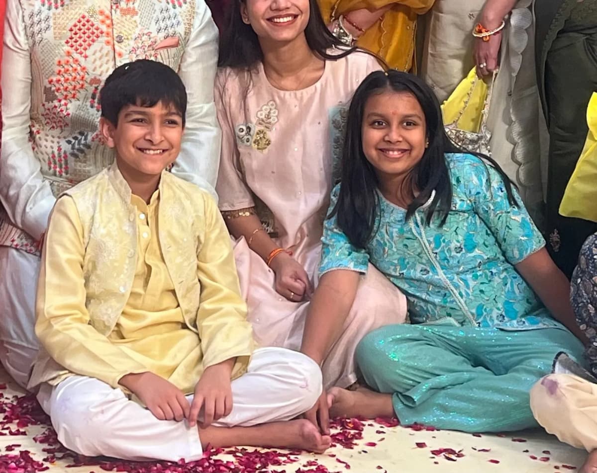 Boy in a pale yellow kurta and girl in a blue kurta set at a family celebration