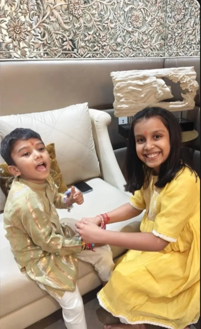 Brother and sister in festive outfits sitting on a sofa