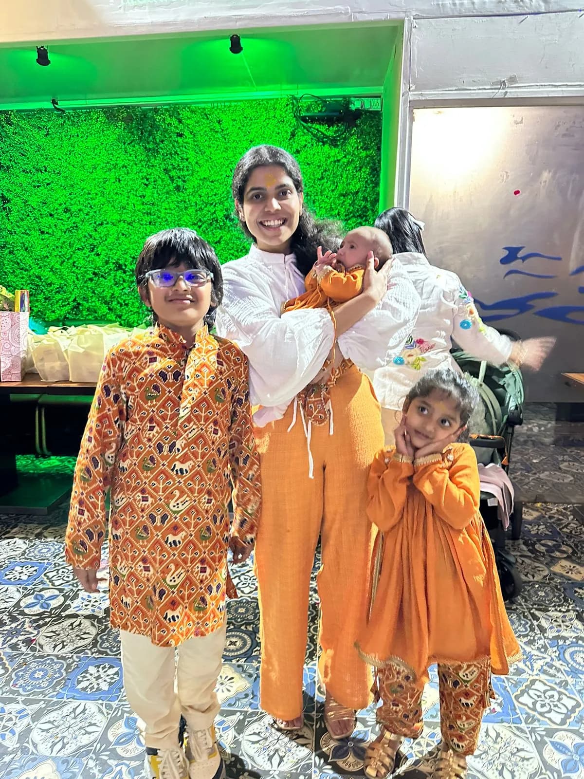 Children and their mother in coordinated orange printed festive outfits