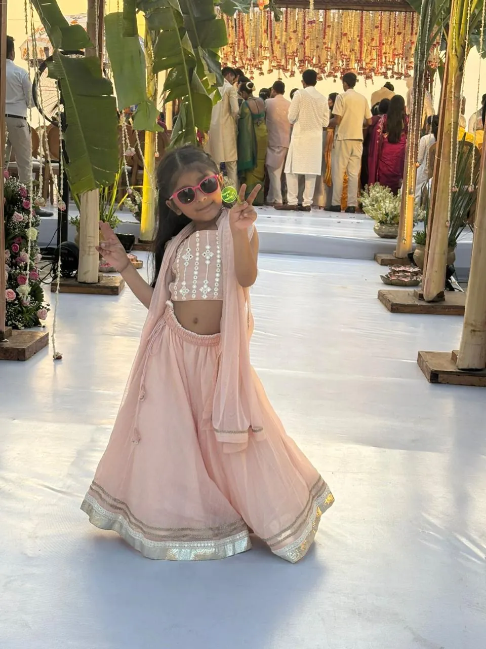 Girl in a peach lehenga posing at a wedding venue
